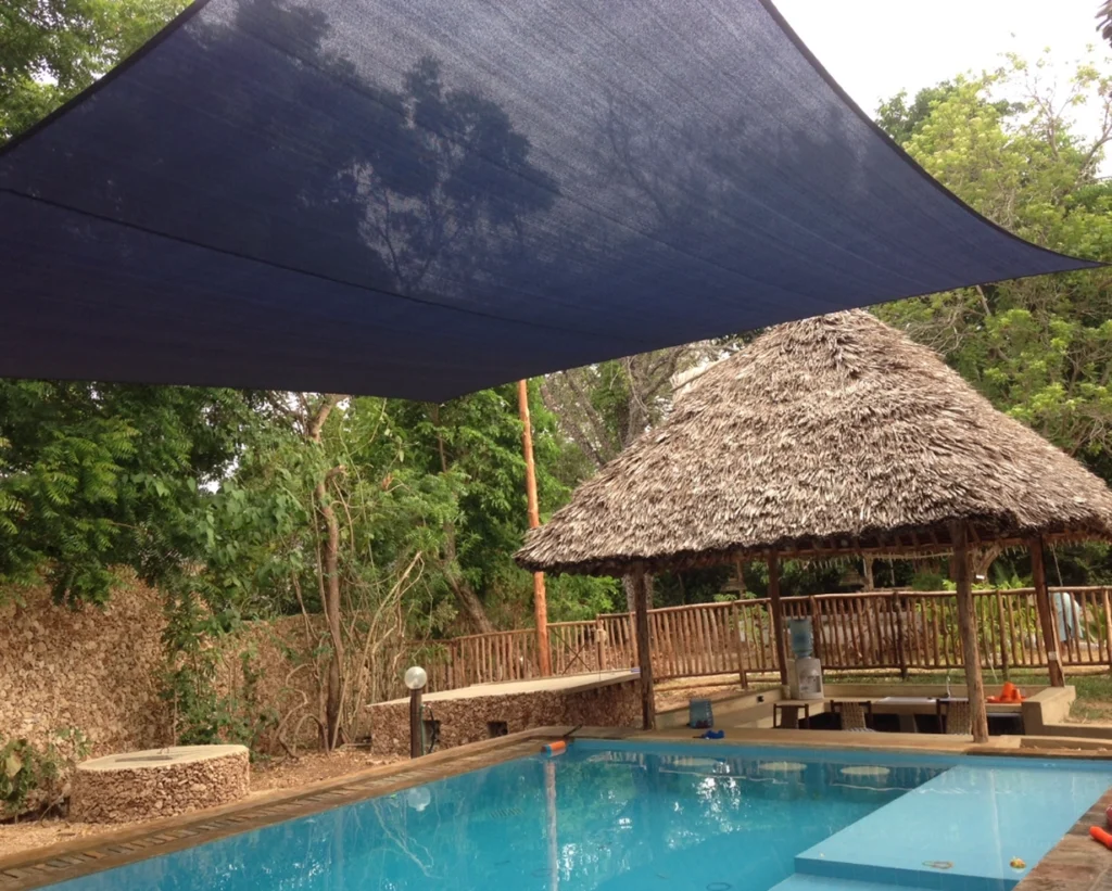 A Blue Shade Sail Stretched Over A Swimming Pool